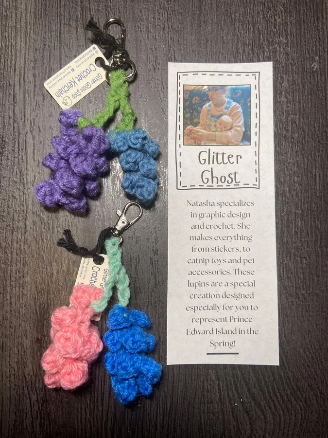 Crocheted lupin keychains in purple and pink with the Glitter Ghost maker card