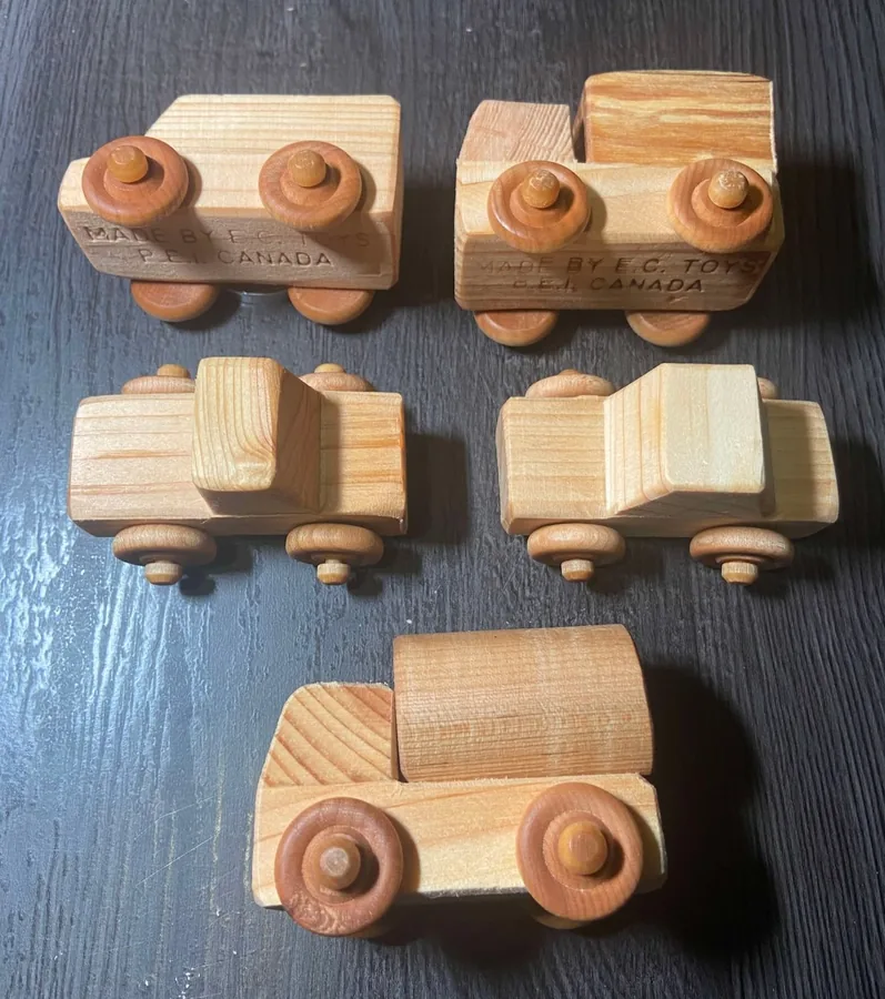 Four small wooden toy cars and trucks by EC Toys