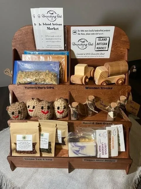 A wooden shelf display of makers&rsquo; goods with Branching Out cards: wooden toy cars, sachets and soaps